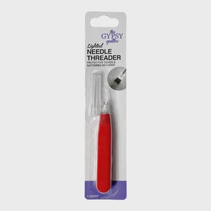 May include: A red and clear lighted needle threader in its original packaging. The packaging includes the text "the Gypsy Quilter" and "Lighted Needle Threader". The threader has a red handle and a clear plastic needle guide.