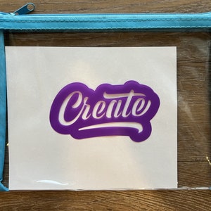 Könnte beinhalten: Eine transparente, durchsichtige Plastiktasche mit Reißverschluss, weißem Hintergrund und einer violetten Vinyl-Schablone mit der Aufschrift "Create".