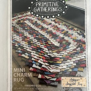 Peut inclure: Un paquet présentant un patron de "Mini Charm Rug" par Primitive Gatherings. Le motif du tapis est composé de petits carrés de tissu colorés. La taille finie est de 50.8cm x 104.1cm ou 47cm x 106.7cm. Le design est étiqueté "Antique Inspired Rug".