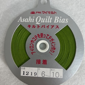 May include: A spool of green bias tape for quilting. The label reads "Asahi Quilt Bias" and includes the color number 1219, width 6 mm, and length 10 meters.