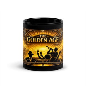 May include: Black ceramic mug featuring a gold illustration with the text "THE GOLDEN AGE". The design depicts a vintage scene with people, a car, and a trumpet player. A stylish mug for coffee or tea.