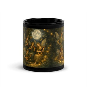May include: Black ceramic mug featuring a fantasy scene of winged figures playing musical instruments under a full moon. The artwork depicts a forest setting with glowing lights, creating a whimsical and enchanting design.