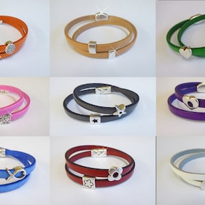 May include: Nine leather bracelets with different colored leather and silver charms. The charms include a heart, a star, a flower, a paw print, a fish, a swirl, a clover, and an infinity symbol.