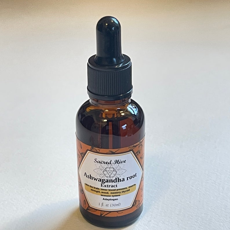 May include: A brown glass bottle with a black dropper top. The bottle is labeled "Sacred Hive Ashwagandha root Extract Adaptogen 1 fl oz (30ml)"