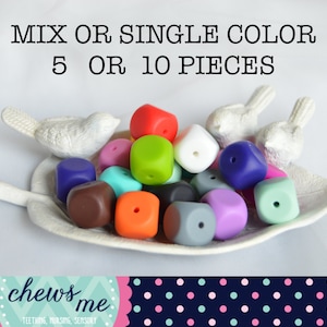 May include: A collection of 10 colorful silicone teether cubes in various colors, including red, green, blue, purple, brown, orange, white, gray, and pink. The cubes are arranged on a white leaf-shaped dish. The text "MIX OR SINGLE COLOR 5 OR 10 PIECES" is displayed above the dish. The text "chews me TEETHING, NURSING, SENSORY" is displayed below the dish.