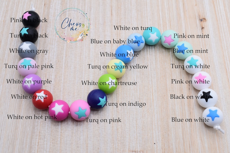 Puede incluir: Primer plano de un collar hecho de cuentas de silicona de colores con dise&ntilde;os en forma de estrella. Las cuentas son de varios colores, incluyendo rosa, azul, verde, amarillo y blanco. Cada cuenta tiene una combinaci&oacute;n de colores diferente, como blanco sobre rosa, azul sobre blanco y rosa sobre menta.