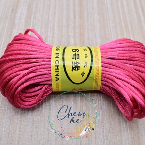 May include: A spool of pink satin cord with a yellow label that reads "6 号 涤纶 绳" and "MADE IN CHINA".