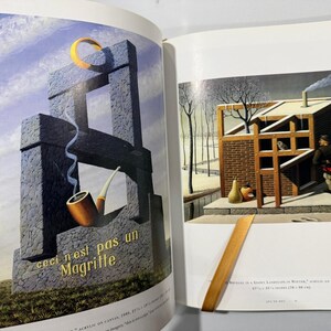 May include: A double-page spread featuring a surrealist painting with a stone structure, a pipe, and the text "ceci n'est pas un Magritte." The artwork includes a yellow crescent and a winter scene.