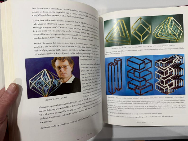 May include: A page from a book showcasing geometric sculptures and a portrait of Guido Moretti. The sculptures include transparent geometric shapes and stacked block designs. The portrait shows a man with glasses, and the text includes the year 2003.