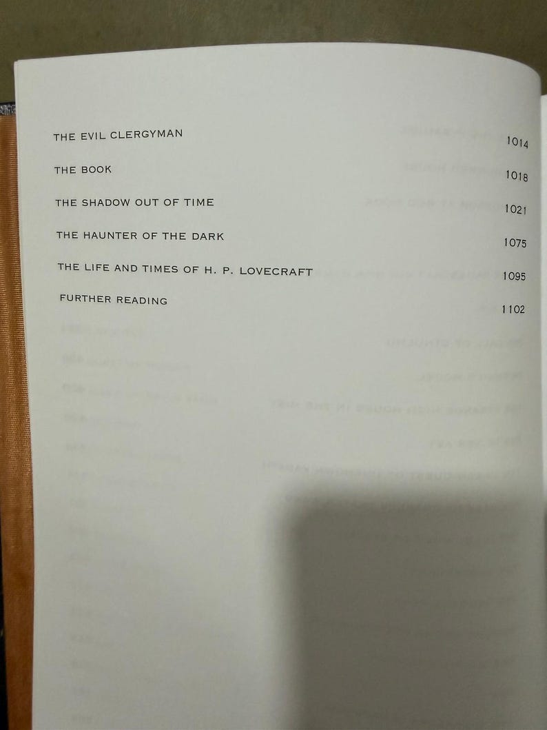 Puede incluir: P&aacute;gina de libro abierta con un &iacute;ndice. T&iacute;tulos como "The Evil Clergyman" y "The Book" est&aacute;n listados. Los n&uacute;meros de p&aacute;gina est&aacute;n a la derecha. El libro tiene una cubierta marr&oacute;n. El texto es negro.