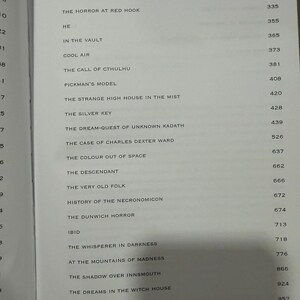 Puede incluir: P&aacute;gina de libro abierta con una lista de t&iacute;tulos y n&uacute;meros de p&aacute;gina. Los t&iacute;tulos incluyen "The Call of Cthulhu" y "The Dunwich Horror". El texto est&aacute; en fuente negra sobre un fondo beige claro.