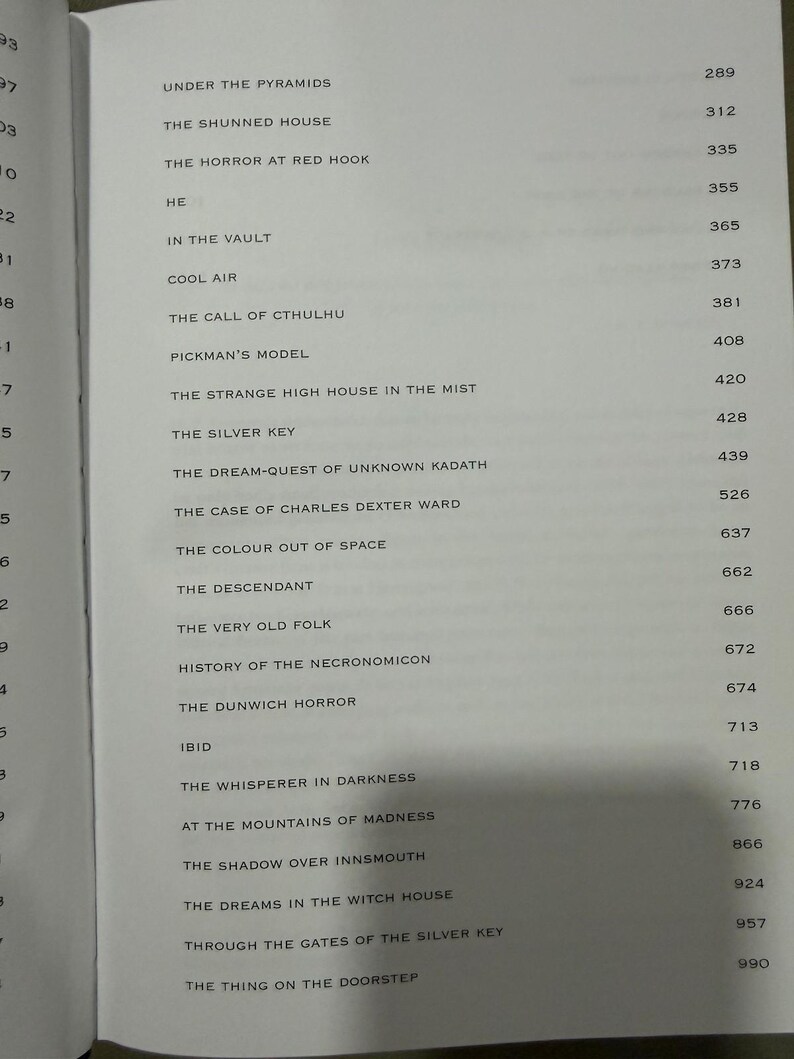 Puede incluir: P&aacute;gina de libro abierta con una lista de t&iacute;tulos y n&uacute;meros de p&aacute;gina. Los t&iacute;tulos incluyen "The Call of Cthulhu" y "The Dunwich Horror". El texto est&aacute; en fuente negra sobre un fondo beige claro.