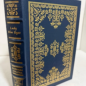 Peut inclure: Une tasse en céramique blanche avec une anse noire et le texte "But First, Coffee" dans un style manuscrit. La tasse est sur une surface blanche. La tasse mesure environ 10 cm de haut.