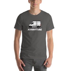 May include: A dark grey t-shirt featuring a white silhouette of a van with a ladder on top. The text "ADVANTURE" is printed in white below the van.