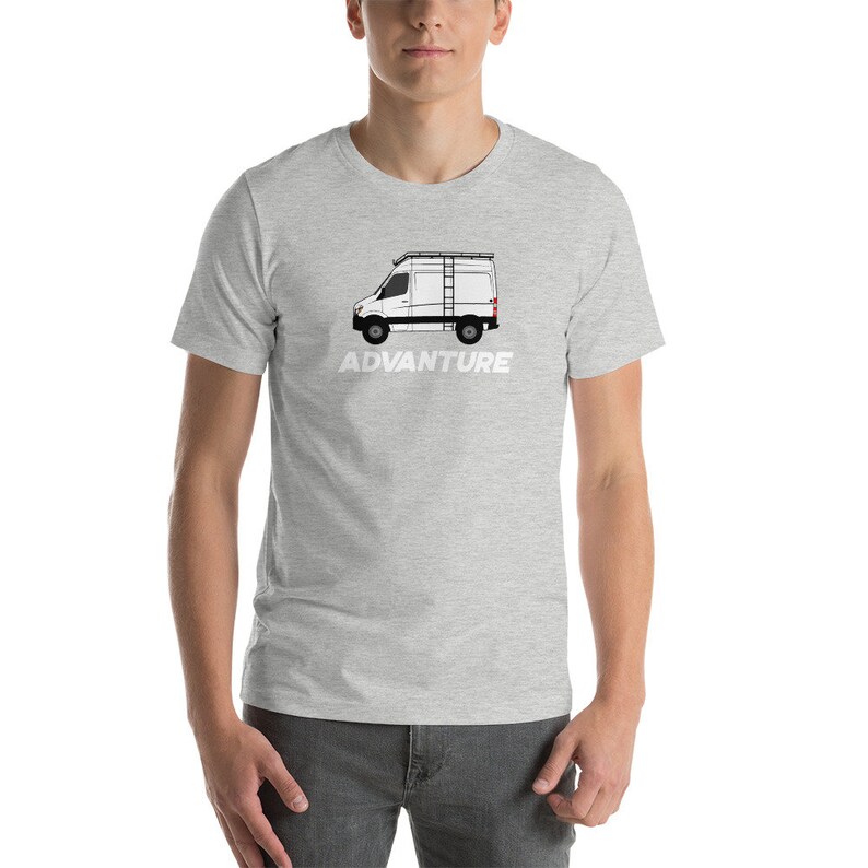 May include: A grey t-shirt featuring a white silhouette of a van with a ladder on top. The text "ADVANTURE" is printed below the van.