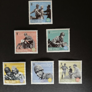 Puede incluir: Una colección de sellos postales de la Isla de Man con imágenes vintage de corredores de motocicletas y otras figuras. Los sellos tienen varios esquemas de color e incluyen texto como "No Limit", "George" y "Speed Demon".