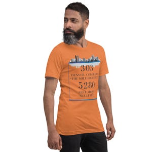 May include: Orange t-shirt with a graphic of the Denver skyline and the text "303 Denver, Colorado - The Mile High City 5280 Feet Above Sea Level".