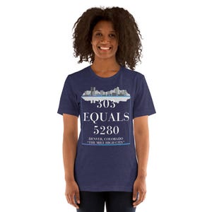 May include: A navy blue t-shirt with a white graphic of a city skyline and the text "303 EQUALS 5280 DENVER, COLORADO -THE MILE HIGH CITY- "