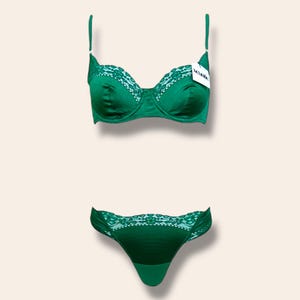 May include: A green satin lingerie set with lace trim. The bra has adjustable straps and a hook and eye closure. The panty is a thong style.