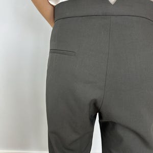 Puede incluir: Primer plano de un pantal&oacute;n negro con un corte a medida. El pantal&oacute;n tiene una cintura alta con un detalle &uacute;nico en forma de V en la parte trasera. Un peque&ntilde;o bolsillo es visible en la parte trasera. La tela parece ser de color liso.