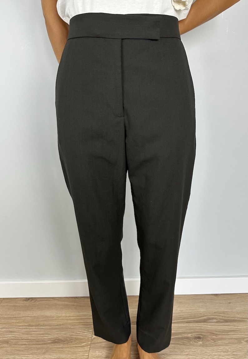 Puede incluir: Pantalones negros con una cintura ancha y pernera recta. Los pantalones tienen un dise&ntilde;o cl&aacute;sico con un ajuste a medida. La tela parece ser de un color oscuro s&oacute;lido, adecuado para diversas ocasiones.