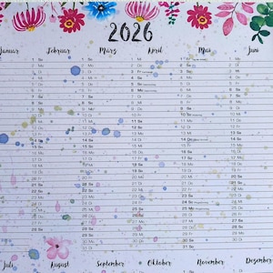 Könnte beinhalten: Ein Kalender für 2026 mit floralem Design oben und farbenfrohen Aquarellspritzern. Der Kalender ist auf Deutsch, mit Monaten und Daten. Das Wort "2026" ist in großer schwarzer Schrift.