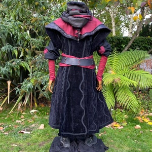 Dark King LARP costume set for nobles, elves & alchemists. Includes black suede waistcoat, layered faux leather hood, wool tunic, hero/ Viking pants, buffalo leather belt, arm wraps & wool sash. Ideal for Ren Faire, cosplay & medieval fantasy events.