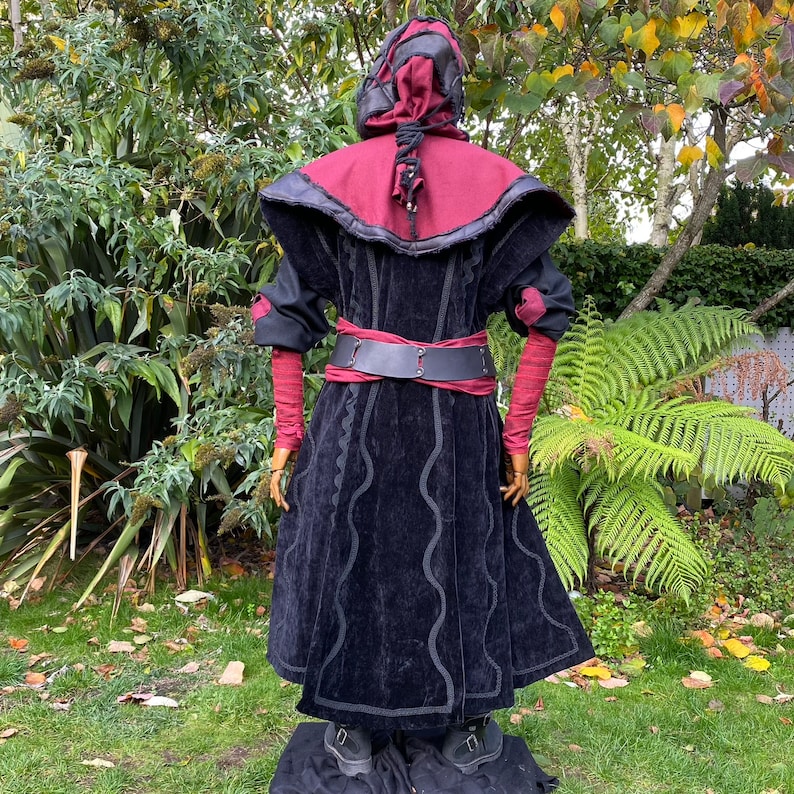 Dark King LARP costume set for nobles, elves & alchemists. Includes black suede waistcoat, layered faux leather hood, wool tunic, hero/ Viking pants, buffalo leather belt, arm wraps & wool sash. Ideal for Ren Faire, cosplay & medieval fantasy events.
