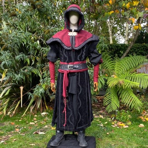 Dark King LARP costume set for nobles, elves & alchemists. Includes black suede waistcoat, layered faux leather hood, wool tunic, hero/ Viking pants, buffalo leather belt, arm wraps & wool sash. Ideal for Ren Faire, cosplay & medieval fantasy events.