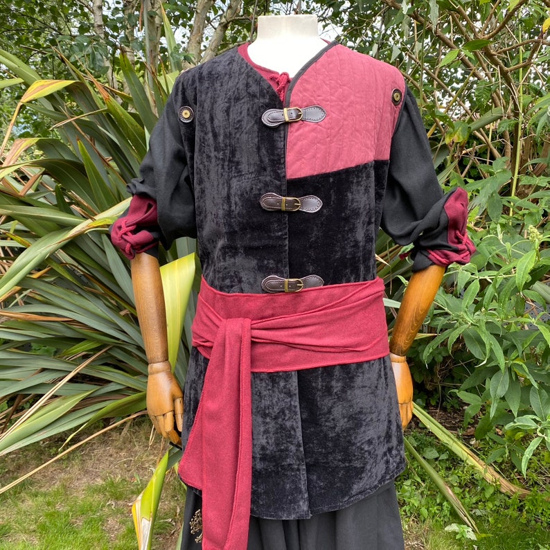 This LARP Gambeson Jacket comes in Black & Red Faux Suede. The LARP Armor has Removeable Sleeves that attach at the shoulder. The Padded Armor is warm and water resistant. This Jacket is perfect for your LARP Costume, Cosplay, and Ren Faires.