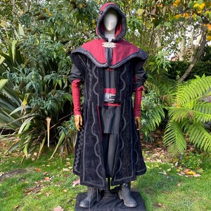 Dark King LARP costume set for nobles, elves & alchemists. Includes black suede waistcoat, layered faux leather hood, wool tunic, hero/ Viking pants, buffalo leather belt, arm wraps & wool sash. Ideal for Ren Faire, cosplay & medieval fantasy events.
