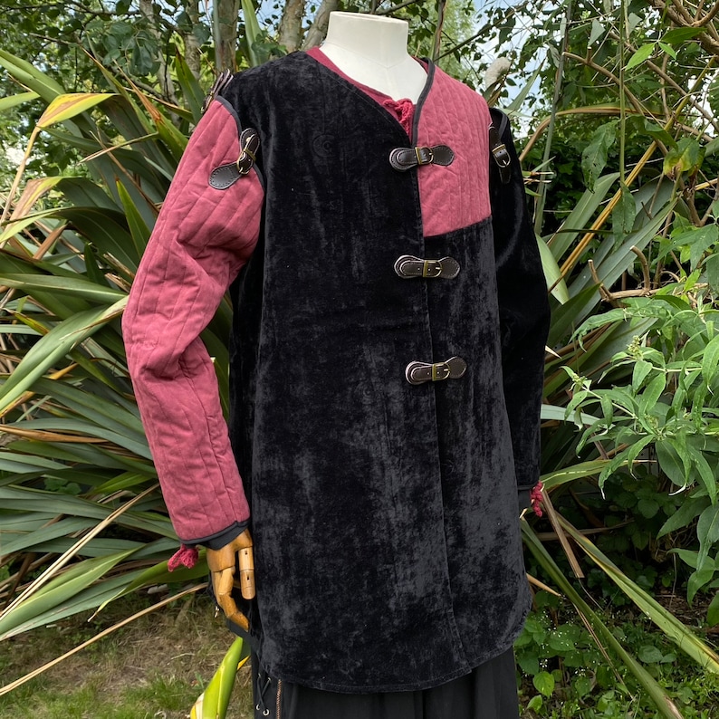 This LARP Gambeson Jacket comes in Black & Red Faux Suede. The LARP Armor has Removeable Sleeves that attach at the shoulder. The Padded Armor is warm and water resistant. This Jacket is perfect for your LARP Costume, Cosplay, and Ren Faires.