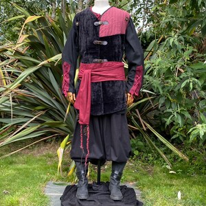 This LARP Gambeson Jacket comes in Black & Red Faux Suede. The LARP Armor has Removeable Sleeves that attach at the shoulder. The Padded Armor is warm and water resistant. This Jacket is perfect for your LARP Costume, Cosplay, and Ren Faires.