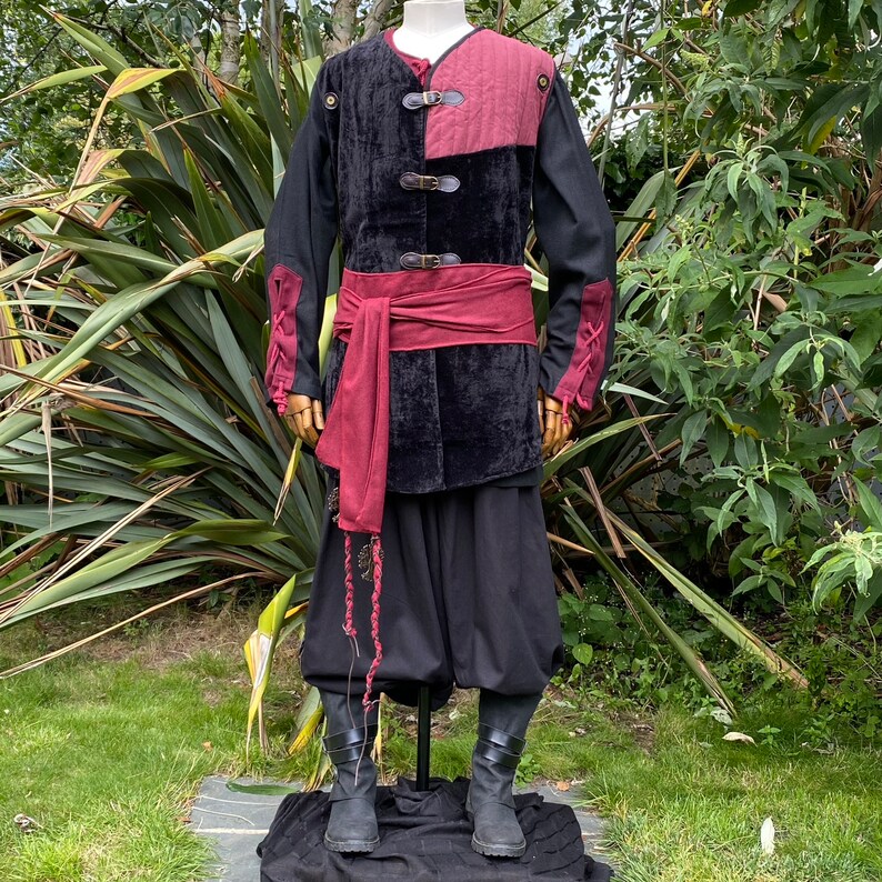 This LARP Gambeson Jacket comes in Black & Red Faux Suede. The LARP Armor has Removeable Sleeves that attach at the shoulder. The Padded Armor is warm and water resistant. This Jacket is perfect for your LARP Costume, Cosplay, and Ren Faires.