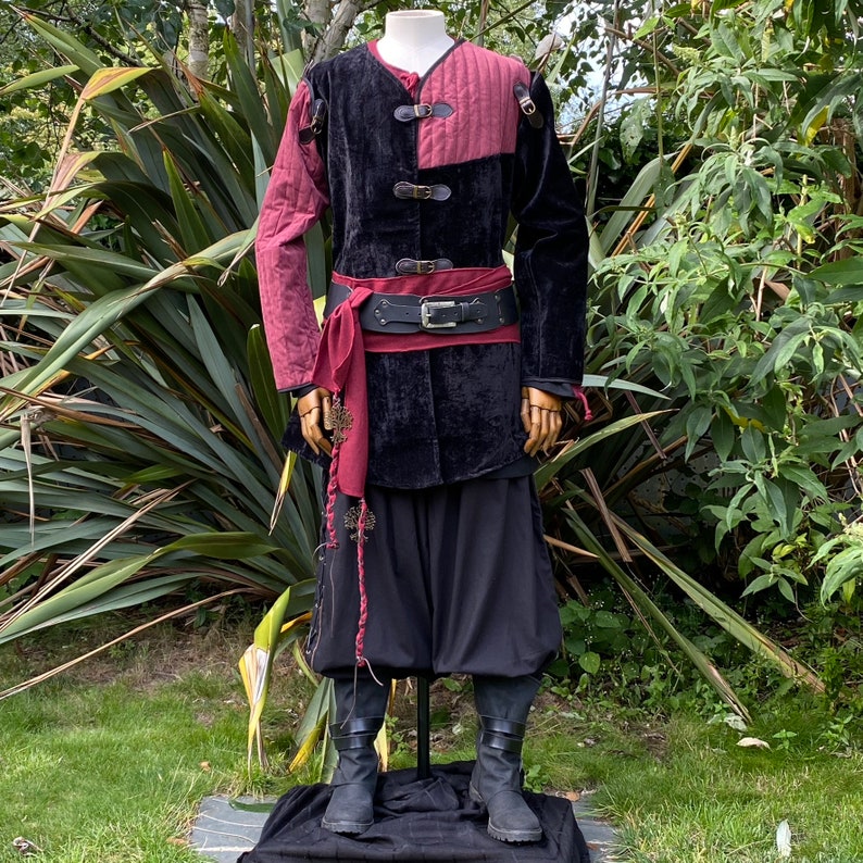 This LARP Gambeson Jacket comes in Black & Red Faux Suede. The LARP Armor has Removeable Sleeves that attach at the shoulder. The Padded Armor is warm and water resistant. This Jacket is perfect for your LARP Costume, Cosplay, and Ren Faires.