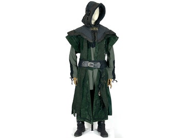 May include: A hooded cloak with a dark green and black patterned design. The cloak has a black leather belt with a metal buckle. The hood is lined with a dark gray fabric.