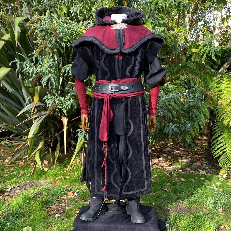 Dark King LARP costume set for nobles, elves & alchemists. Includes black suede waistcoat, layered faux leather hood, wool tunic, hero/ Viking pants, buffalo leather belt, arm wraps & wool sash. Ideal for Ren Faire, cosplay & medieval fantasy events.