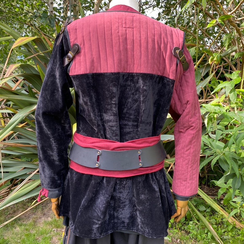 This LARP Gambeson Jacket comes in Black & Red Faux Suede. The LARP Armor has Removeable Sleeves that attach at the shoulder. The Padded Armor is warm and water resistant. This Jacket is perfect for your LARP Costume, Cosplay, and Ren Faires.