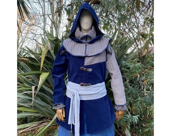 Puede incluir: Una chaqueta azul y gris con capucha, con un diseño acolchado y un cinturón. La chaqueta tiene un cuello alto y una capucha larga y fluida. La chaqueta está hecha de una tela suave y cómoda y tiene un diseño clásico y atemporal.