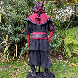 Dark King LARP costume set for nobles, elves & alchemists. Includes black suede waistcoat, layered faux leather hood, wool tunic, hero/ Viking pants, buffalo leather belt, arm wraps & wool sash. Ideal for Ren Faire, cosplay & medieval fantasy events.