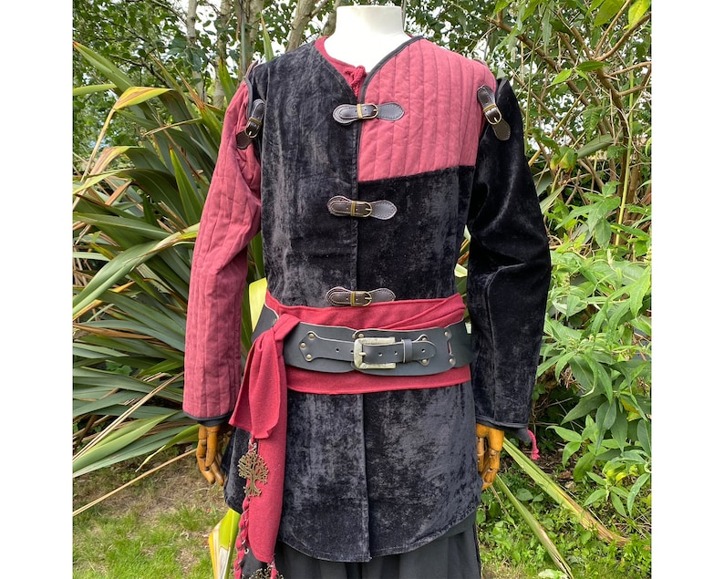 This LARP Gambeson Jacket comes in Black & Red Faux Suede. The LARP Armor has Removeable Sleeves that attach at the shoulder. The Padded Armor is warm and water resistant. This Jacket is perfect for your LARP Costume, Cosplay, and Ren Faires.