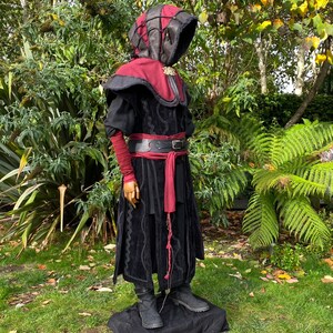 Dark King LARP costume set for nobles, elves & alchemists. Includes black suede waistcoat, layered faux leather hood, wool tunic, hero/ Viking pants, buffalo leather belt, arm wraps & wool sash. Ideal for Ren Faire, cosplay & medieval fantasy events.