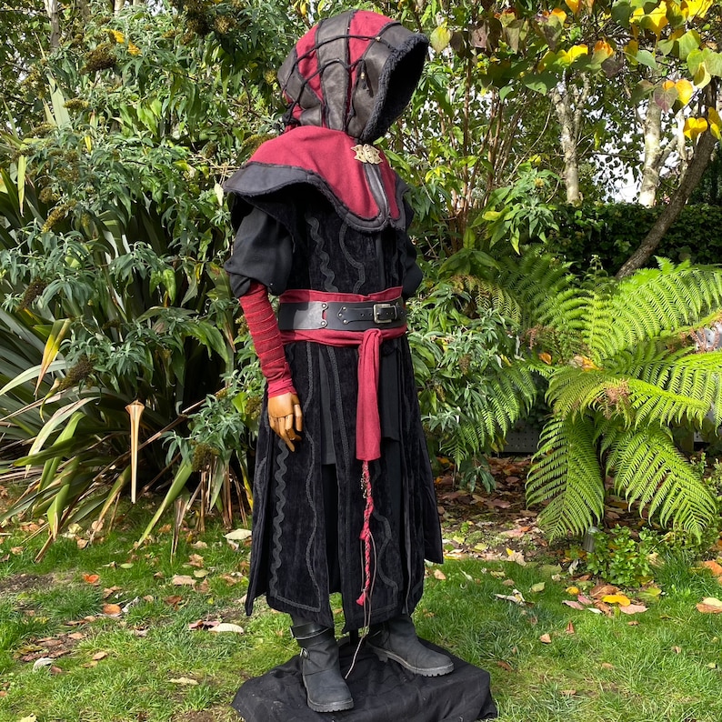 Dark King LARP costume set for nobles, elves & alchemists. Includes black suede waistcoat, layered faux leather hood, wool tunic, hero/ Viking pants, buffalo leather belt, arm wraps & wool sash. Ideal for Ren Faire, cosplay & medieval fantasy events.
