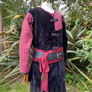 This LARP Gambeson Jacket comes in Black & Red Faux Suede. The LARP Armor has Removeable Sleeves that attach at the shoulder. The Padded Armor is warm and water resistant. This Jacket is perfect for your LARP Costume, Cosplay, and Ren Faires.