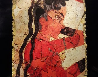 Pode incluir: Um fragmento de um fresco antigo que retrata uma pessoa com cabelo escuro e uma roupa vermelha. O fresco é pintado em uma superfície de gesso e mostra sinais de idade e danos.