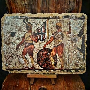 May include: A rectangular, aged stone tablet featuring a painted scene of two figures in ancient attire. One figure holds a spear, the other a flag. A large, round shield is between them. The color palette includes browns, reds, and creams.