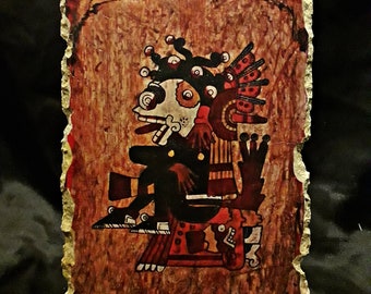 May include: A hand-painted stone plaque depicting a multi-eyed, red and black deity with a headdress. The deity is seated on a throne with a red and black design. The background is a brown and red color.