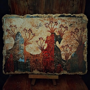May include: An antique-style painting on a rectangular, textured surface. The artwork features a landscape with trees and figures in shades of red, blue, and brown. The painting is displayed on a small wooden easel, with a dark wooden background.