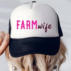 May include: A white and black trucker hat with a pink embroidered design that says "FARMwife".