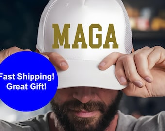 May include: White trucker hat with a gold embroidered "MAGA" logo.